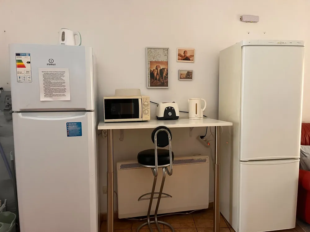 Zona de cocina compartida del Hostal Matilda's: neveras, microondas, tostadora y hervidor de agua